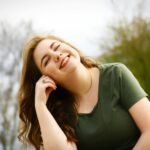 A carefree woman enjoying a sunny day outdoors, expressing pure happiness and relaxation.